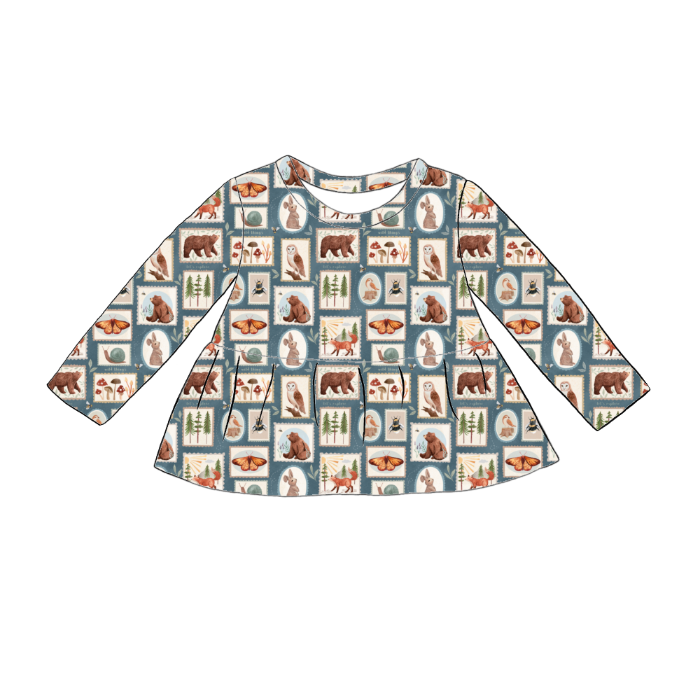 Handmade long sleeved peplum top in Wild Stamps – tile-style woodland print featuring animals, toadstools and trees on a dusky blue background.