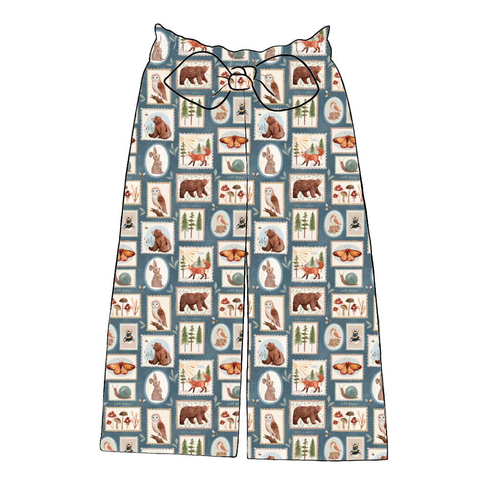 Handmade wide leg paperbag trousers in Wild Stamps – dusky patchwork print with woodland creatures, foliage and soft autumn tones.