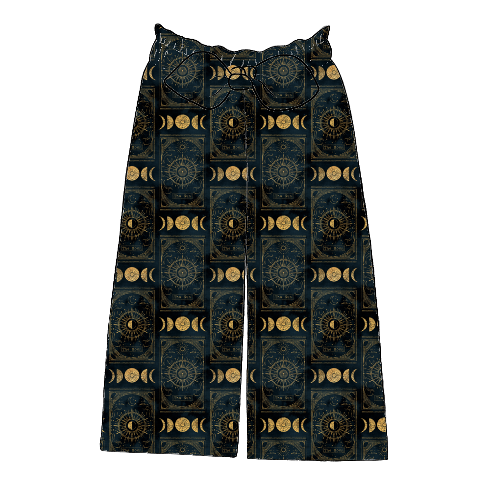 Children’s paperbag trousers in Tarot – dark midnight jersey with gold sun, moon and tarot motifs, wide leg cut with bow detail.