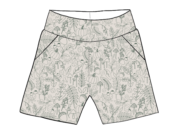 Children’s pocket shorts in cream fabric with sage green autumn-themed line drawings of leaves and pumpkins.