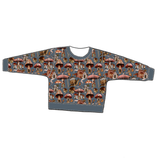 Handmade lounge sweater in Mushroom Town – blue-grey jersey with mushroom houses, snails and toadstools, finished with ribbed cuffs and hem.