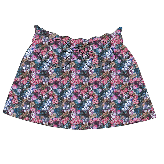 Children’s paperbag shorts in Matilda fabric – navy base with bright painterly flowers in pink, blue and lilac, with ruffle waist and bow.