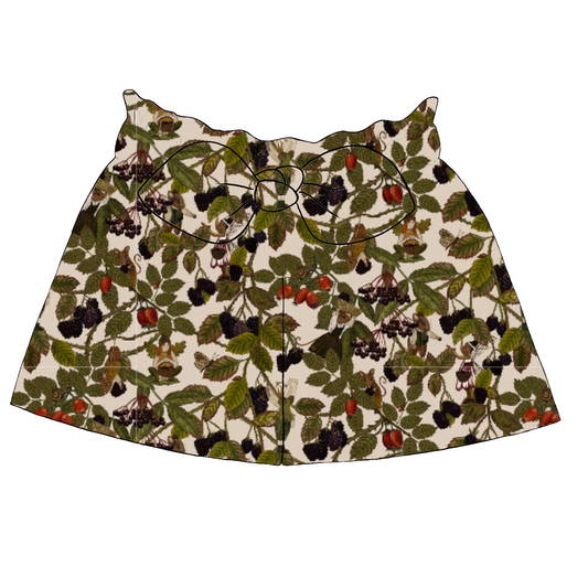 Children’s paperbag shorts in Hedgerow fabric – light background with woodland details like brambles, blackberries, birds and fairies, finished with ruffle waistband and bow.