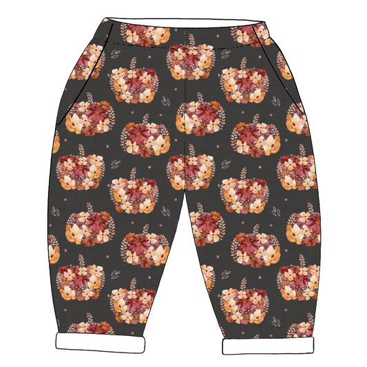 Slouchy children’s trousers in Baize – charcoal base with floral pumpkins, comfy pockets and a rolled hem finish.