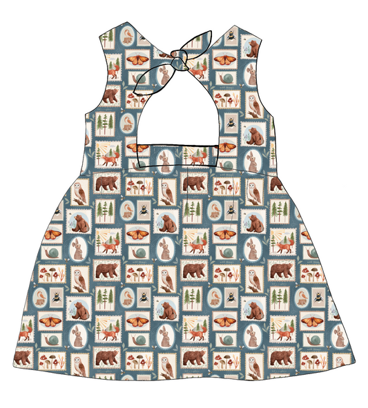 Bow Back Dress in Wild Stamps – tile-style woodland print with foxes, bees and trees in dusky blue and rust, with lined bodice and bow detail at the back.