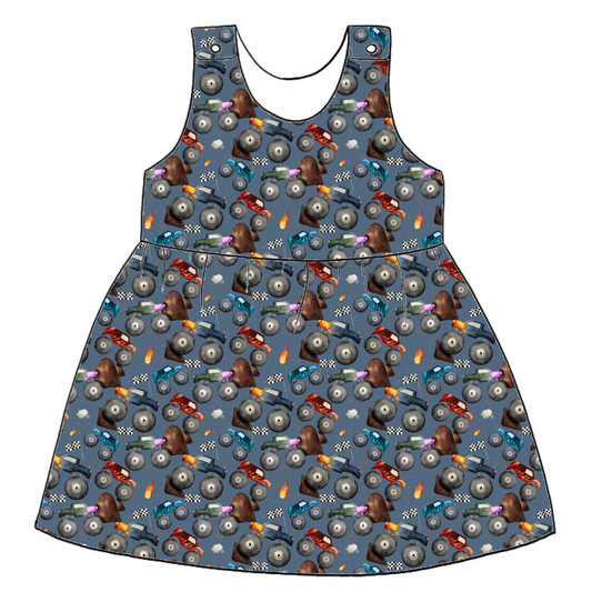 Handmade pinafore dress in Monster Trucks – soft blue jersey with colourful monster trucks, flames and racing details. Popper shoulder straps and gathered skirt.