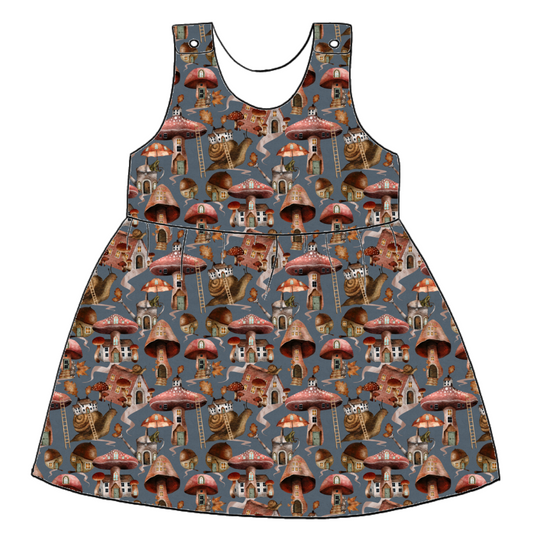Handmade pinafore dress in Mushroom Town – blue-grey jersey with whimsical mushroom houses, snails and toadstools. Gathered skirt and popper straps.