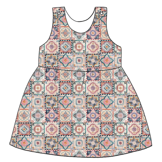 Handmade pinafore dress in Faro – tile-style jersey print in terracotta, blush, navy and soft green. Finished with popper fastening straps.