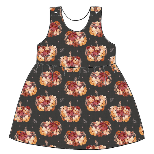 Handmade pinafore dress in Baize – charcoal jersey with peach and burgundy floral pumpkins. Finished with popper straps and a softly gathered skirt.