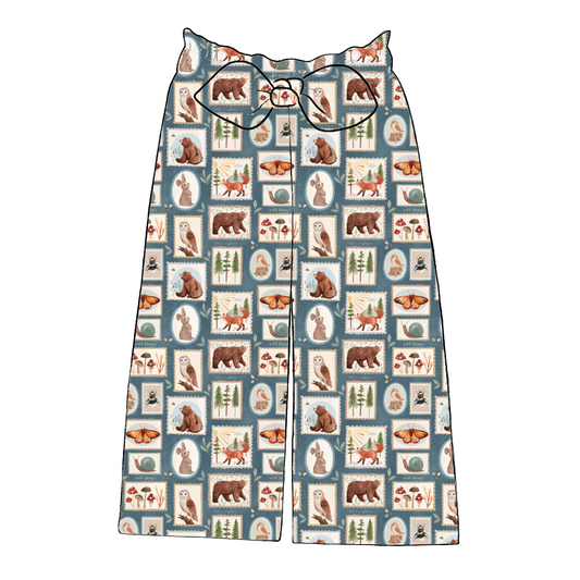 Handmade wide leg paperbag trousers in Wild Stamps – dusky patchwork print with woodland creatures, foliage and soft autumn tones.