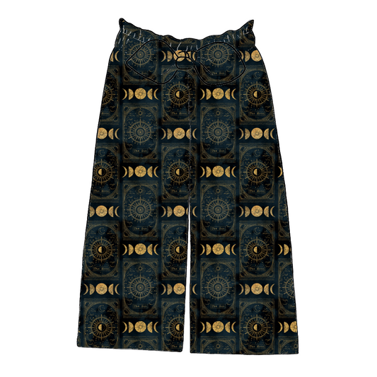 Children’s paperbag trousers in Tarot – dark midnight jersey with gold sun, moon and tarot motifs, wide leg cut with bow detail.
