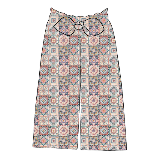 Children’s wide leg paperbag trousers in Faro – colourful tile print with elasticated waist and statement bow.
