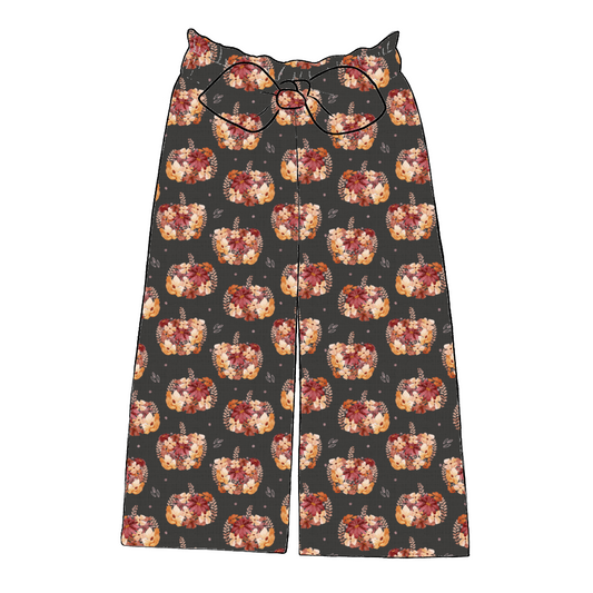 Children’s wide leg paperbag trousers in Baize – charcoal jersey with painterly pumpkins and autumn florals, finished with elastic waist and bow.