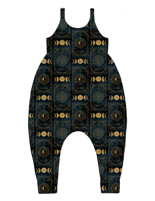 Handmade Napa Romper in Tarot – black and gold jersey with celestial motifs, stars, moons and suns. Harem-style legs and soft cuffs.