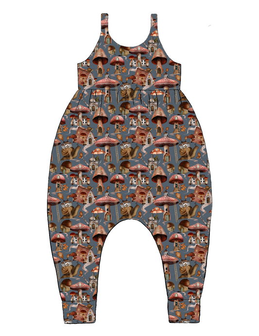 Handmade Napa Romper in Mushroom Town – blue-grey jersey with whimsical mushroom houses, snails and leaves. Relaxed fit with harem-style legs.