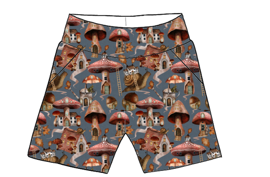 Children’s handmade pocket shorts in Mushroom Town fabric – blue base with mushroom houses, snails, trees and forest-inspired illustrations.