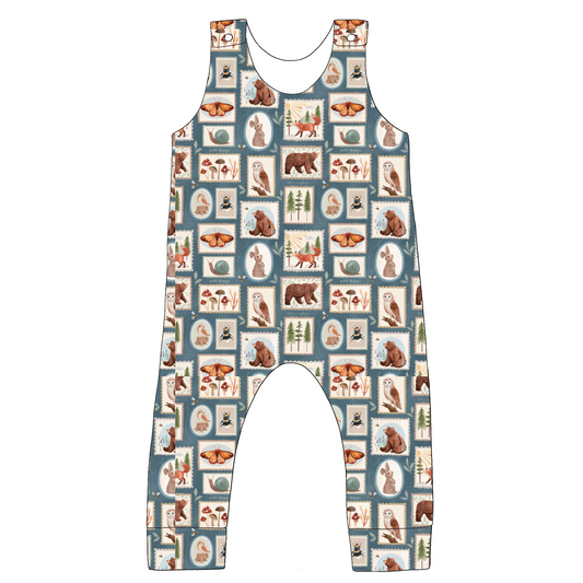 Standard romper in Wild Stamps fabric – illustrated animal and foliage print in neutral tones, with soft jersey fit and popper shoulder fastening.